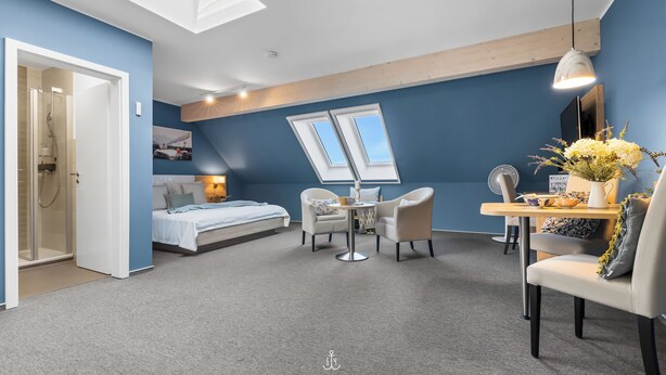 Un dormitorio moderno con tragaluces, una cama, un escritorio y una silla.