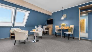 A modern room with a blue wall, a skylight, a desk, and two chairs.