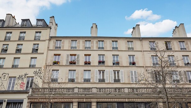 A row of multi-story buildings with balconies, large windows, and a clear sky. - Superb 3 Bedroom Flat in the Center of Paris (Paris)