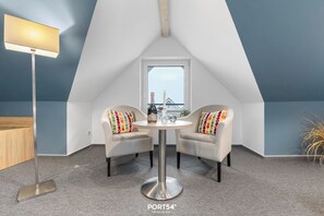 Relax or work in a serene space with a round table, two chairs, and a floor lamp.