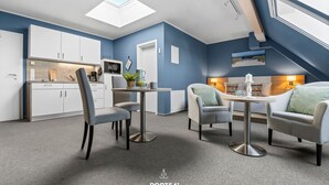 A modern interior with a dining area, kitchen, and seating space. - Bude 8 directly on the dike in Dagebüll for 2 persons with water view (Dagebüll)