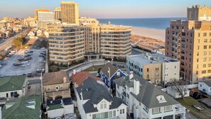 Un paysage urbain côtier avec de hauts immeubles, un parking et une plage en arrière-plan.
