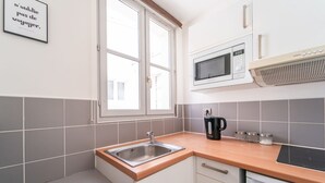 Una cocina moderna con lavamanos, microondas y estufa.