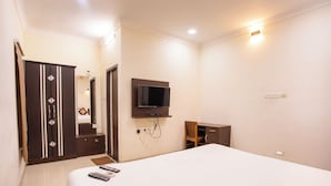 Une chambre d’hôtel équipée d’un lit, d’un téléviseur fixé au mur, d’une armoire et d’un bureau.