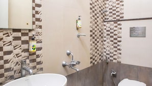 Une salle de bain avec un grand lavabo blanc, des toilettes et un espace douche.
