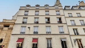 A multi-story building with balconies, large windows, and awnings. - Cosi Apartment Bastille-le Marais (Paris)