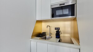 A compact kitchen with a stainless steel sink, a microwave, and a coffee machine. - Cosi Apartment Bastille-le Marais (Paris)