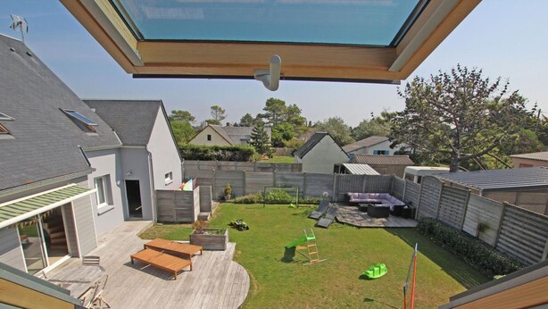 A modern house with a large deck, a patio, and a backyard with a lawn and a play area. - Spacious house near the beach, perfect for families, pets allowed (Saint-Germain-sur-Ay)