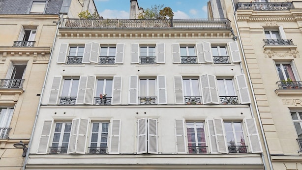 A multi-story building with white facades, multiple balconies, and shutters. - The Upper Marais Superb Apartment for 8 People (Paris)