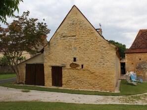 A stone building with a triangular roof, a wooden door, and a small window.