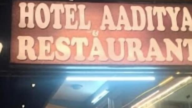 A sign for a hotel and restaurant with a neon sign. - Hotel Aaditya (Kullu)