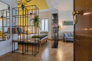 A modern living room with a bed, a sofa, a bookshelf, and a door. - Cinema & Bamboo Flats by Wonderful Italy (Turin)