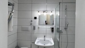 Ein modernes Badezimmer mit Toilette, Waschbecken und Dusche.