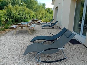 A patio area with outdoor seating, including lounge chairs and a table with a bench. - Modern studio with WiFi and parking in Baignes (Baignes-Sainte-Radegonde)