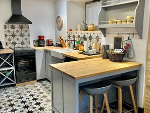 A compact kitchen with a central island, a stove, and a sink.
