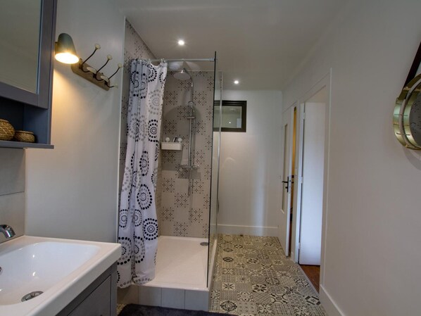Ein modernes Badezimmer mit Dusche, Waschbecken und einer duschkabinenbespanung mit Muster.