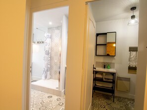 A bathroom with a shower, a sink, and a mirror.