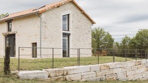 A modern house with a stone facade, large windows, and a tiled roof. - Charming house with air conditioning, WiFi and pets allowed in Puycousin (Sorges et Ligueux en Périgord)