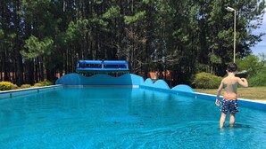 Una piscina con plataforma azul y un niño de pie en el borde.