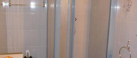 A bathroom with a blue sink, a toilet, and a shower area.