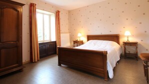 A bedroom with a wooden bed, two bedside tables with lamps, a wardrobe, and a window with curtains. - Family house in Gouville-sur-Mer, near the English Channel, pets allowed (Gouville-sur-Mer)