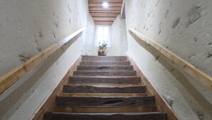 Eine Holztreppe mit Holzwandläufen auf beiden Seiten, die zu einem Fenster oben führt.