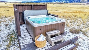 A hot tub on a wooden deck with a mountain backdrop. - Yellowstone Fun House | Hot Tub, Game Room + 360° Views (Emigrant)