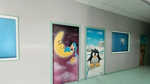 A hallway with doors featuring cartoon characters and a star. - Hostel Las Rosas (Madrid)