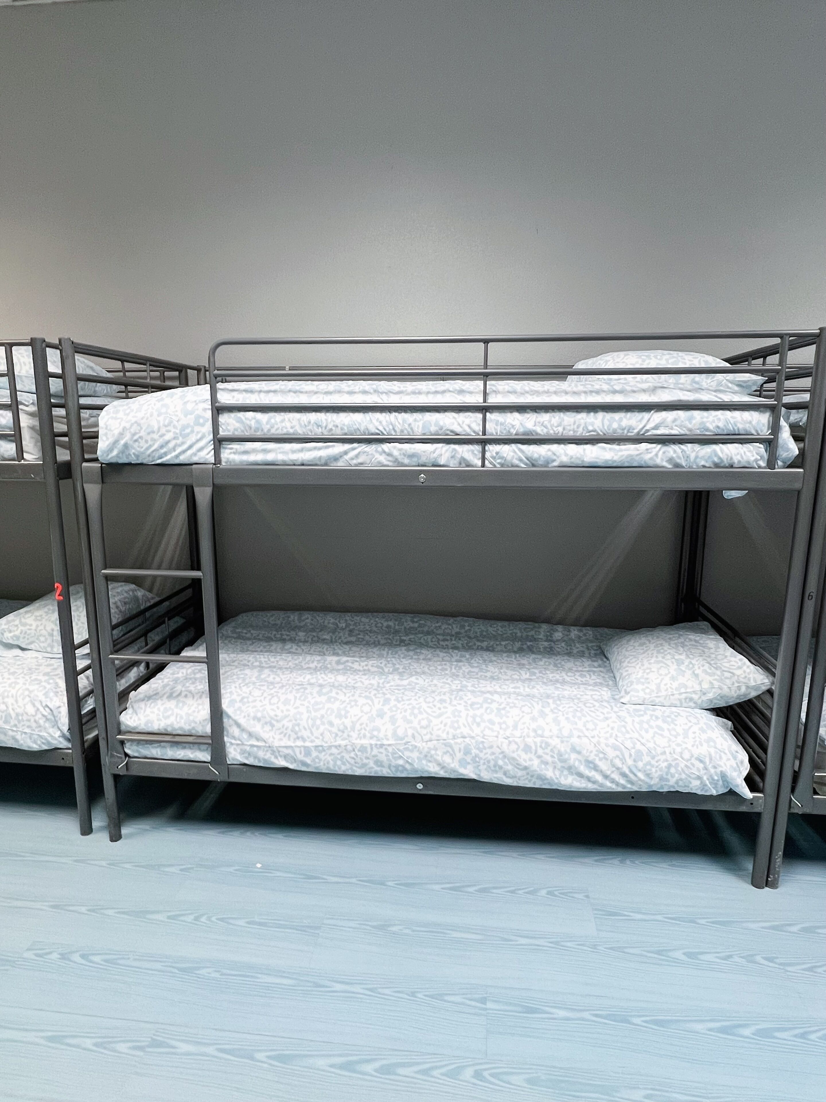 Una cama litera con tres niveles, cada uno con un colchón y almohadas.