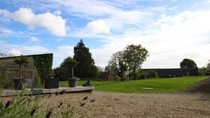 A gravel driveway leading to a grassy area with a stone bench and potted plants. - Semi-detached house with balcony in countryside, Wi-Fi, parking, pets allowed (Saint-Laurent-de-Terregatte)