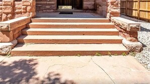 A stone building with a wooden porch and steps leading to a door marked "FACP." - Lioness Downtown Den (Denver)