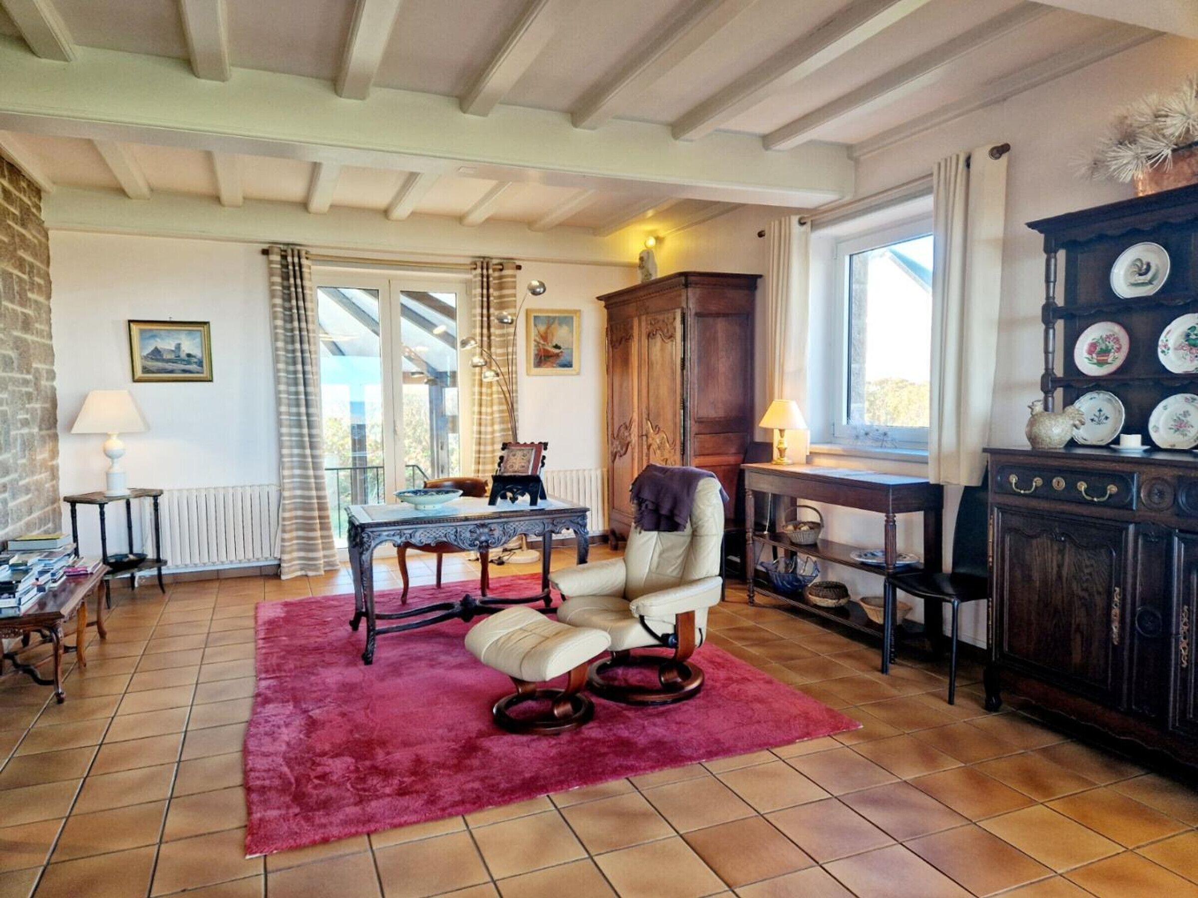 Uma sala de estar acolhedora com lareira, uma mesa de jantar e uma poltrona confortável.