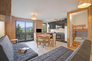 Ein gemütliches Blockhaus mit Essbereich, Küche und einem Balkon mit Bergblick.