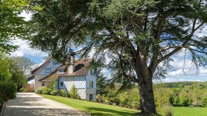 A large house with a gravel driveway, surrounded by lush greenery and trees. - Blueberry of the Valley - House With Swimming Pool (Saint-Pierre-Azif)