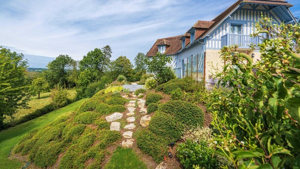 A traditional half-timbered house with a stone pathway leading to the entrance, surrounded by lush greenery and trees. - Blueberry of the Valley - House With Swimming Pool (Saint-Pierre-Azif)