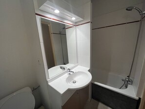 A modern bathroom with a white sink, mirror, and shower. - Apartment with heated pool and parking in Cauterets (Cauterets)