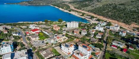Vista aérea de uma cidade costeira com edifícios, estradas e litoral.