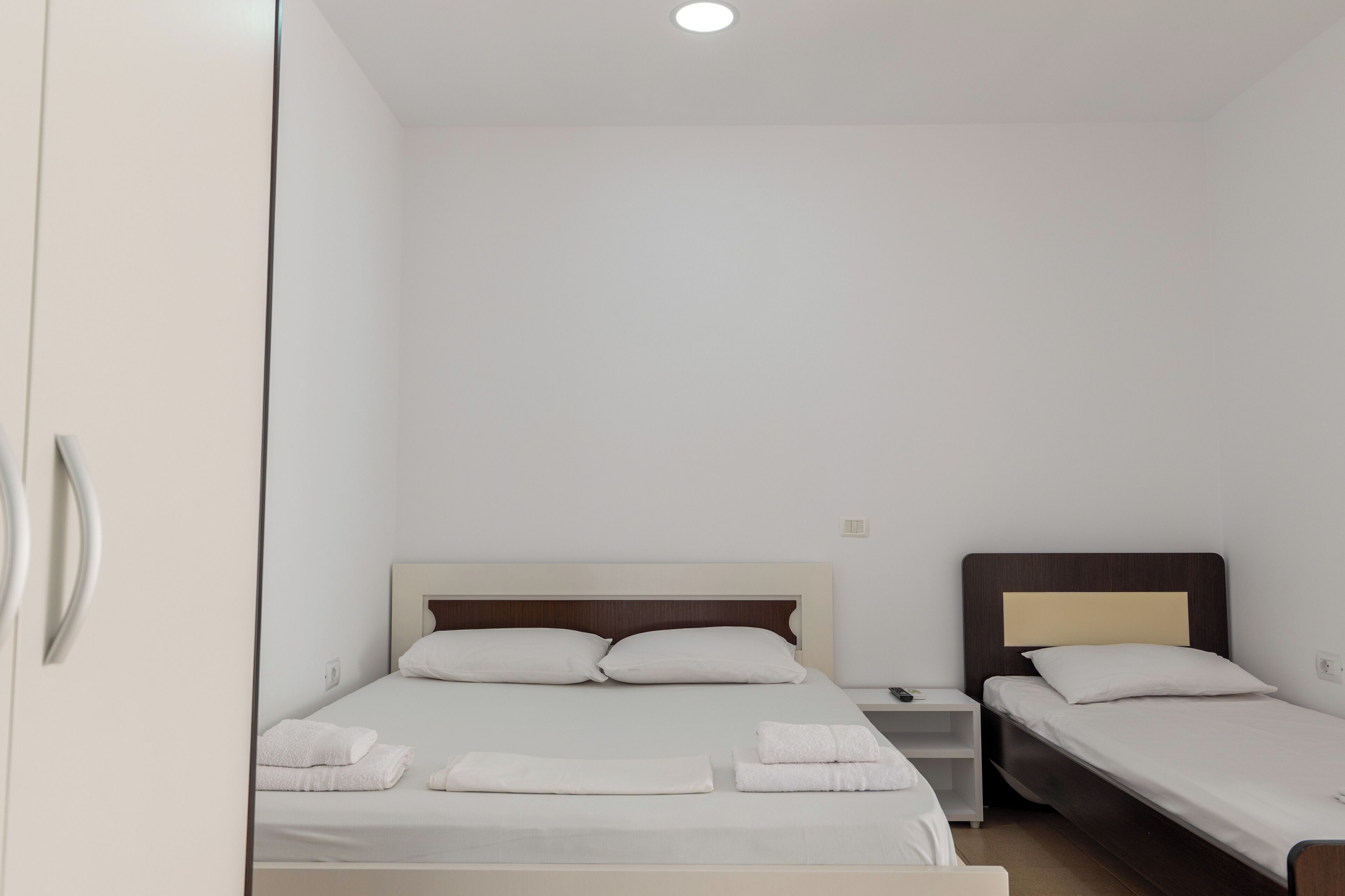 Ein Hotelzimmer mit einem Einzelbett, einem Nachttisch und einem kleinen Schreibtisch.