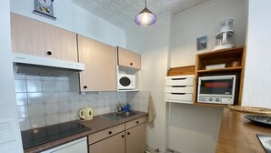 Une cuisine compacte équipée d’un four à micro-ondes, d’un évier et d’un petit réfrigérateur.