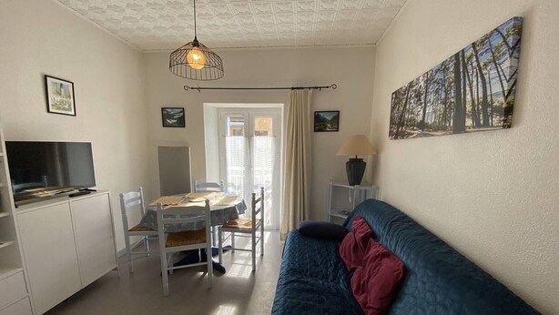 Un espace de vie compact comprenant une kitchenette, un coin repas et un canapé.