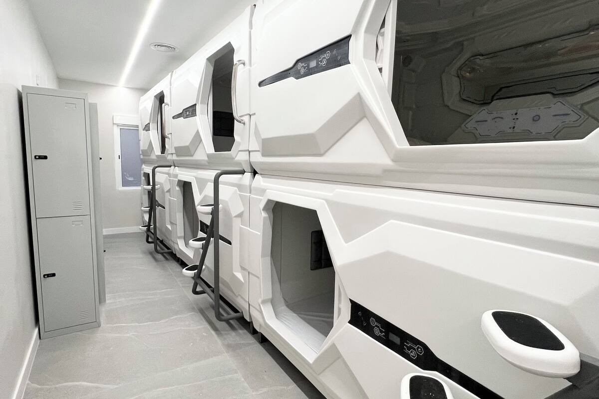 A row of modern, white, high-tech toilets with individual privacy screens and ventilation outlets.