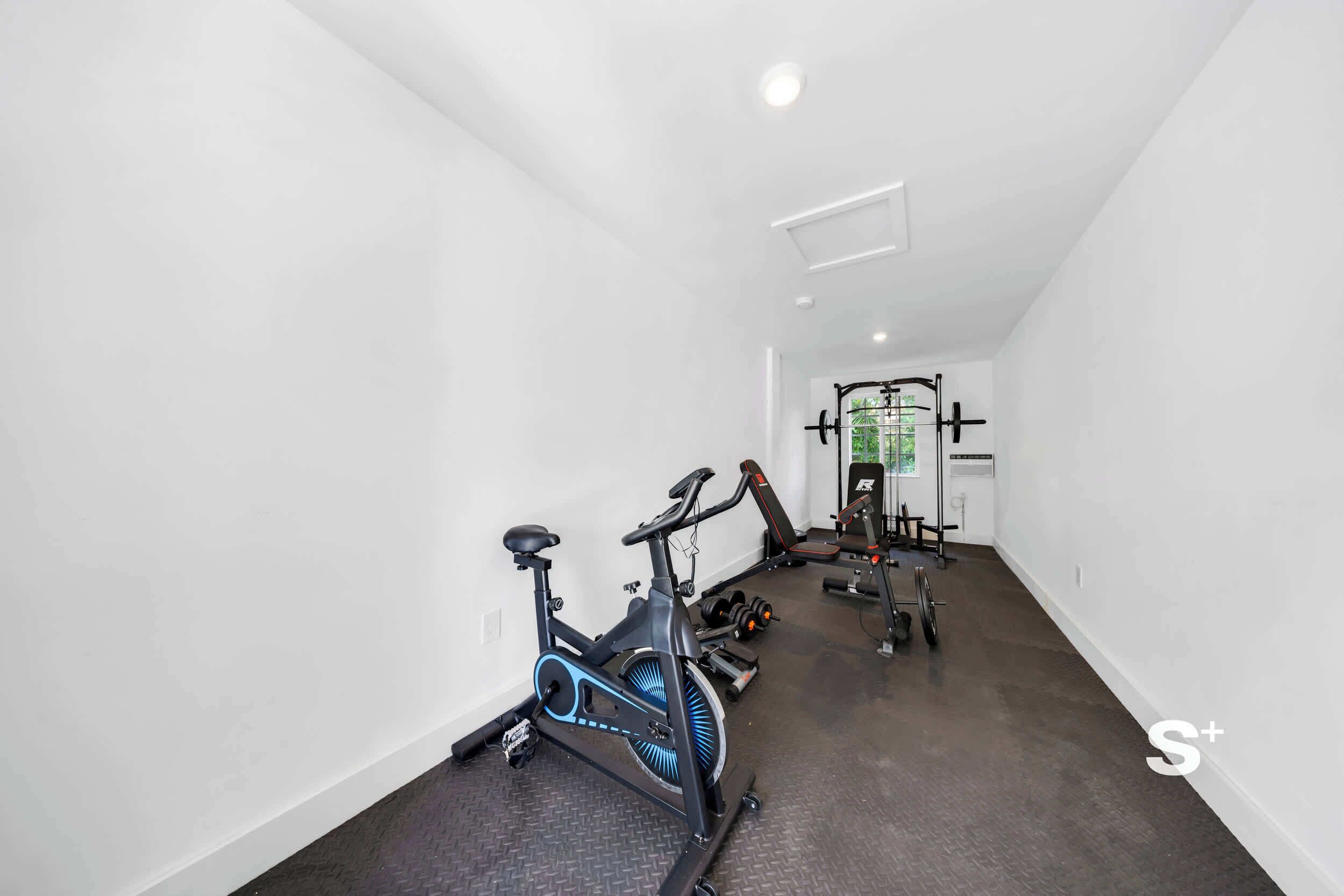 A gym with exercise equipment, including a stationary bike and weight machines.