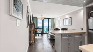 A modern kitchen with grey cabinets, a wooden countertop, and a view to the outside.