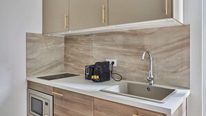 Una cucina con due lavandini, forno a incasso e macchina da caffè.