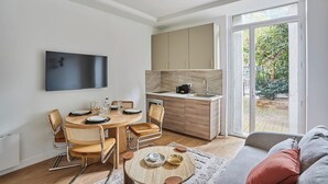 Una cucina moderna con angolo ristoro, divano e televisore.