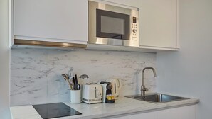 A modern kitchen with a built-in microwave, toaster, and sink. - Amazing Studio Le Marais (Paris)