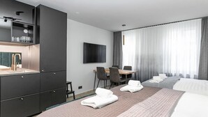 A modern hotel room with a large bed, a desk, and a TV. - Backyard Stylish Studio for 4 - Excellent Location (Reykjavík)
