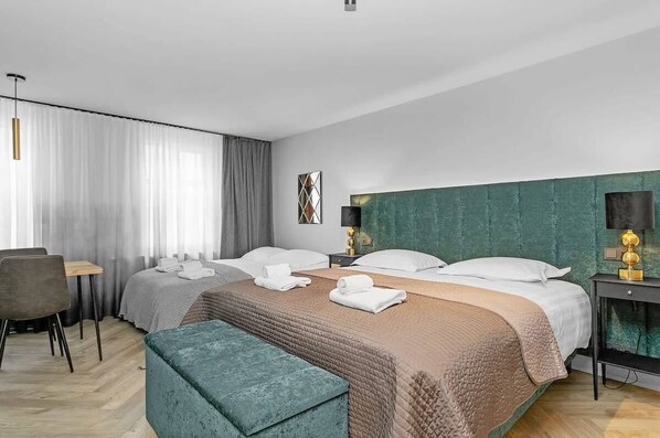 A modern hotel room with two beds, a desk, a chair, and a bench. - Backyard Stylish Studio for 4 - Excellent Location (Reykjavík)