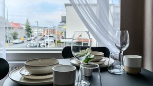 Une table dressée pour le dîner, avec vue sur la rue et les bâtiments environnants.