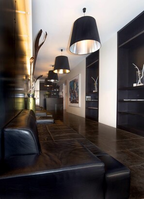 A modern lobby with leather seating, black pendant lighting, and a minimalist decor. - Mani Apartments - Budget Studio (Reykjavík)